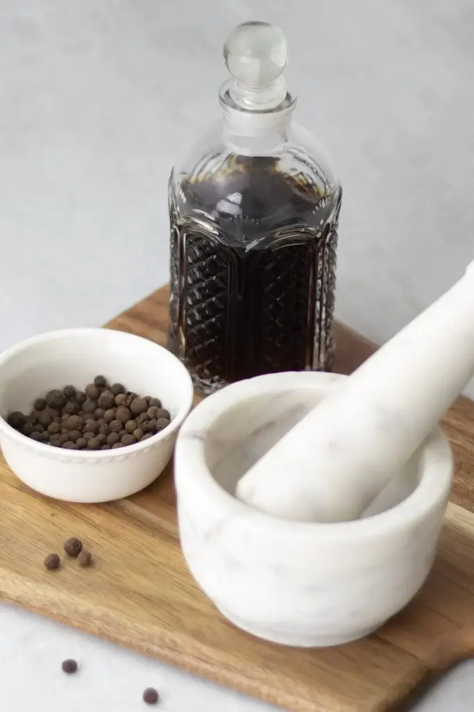 allspice dram in a bottle with a mortar and pestle