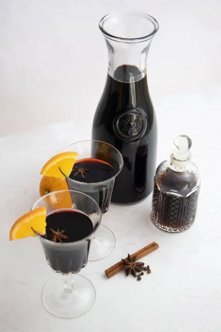 A carafe of red wine and two bishop cocktails