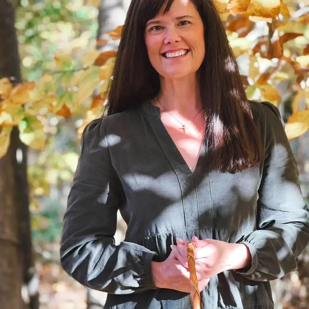 Andrea McEvoy standing in the fall woods at peak color