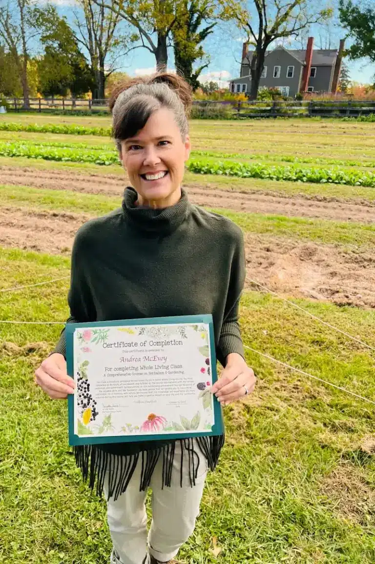 Andrea McEvoy standing with her community herbalism certificate